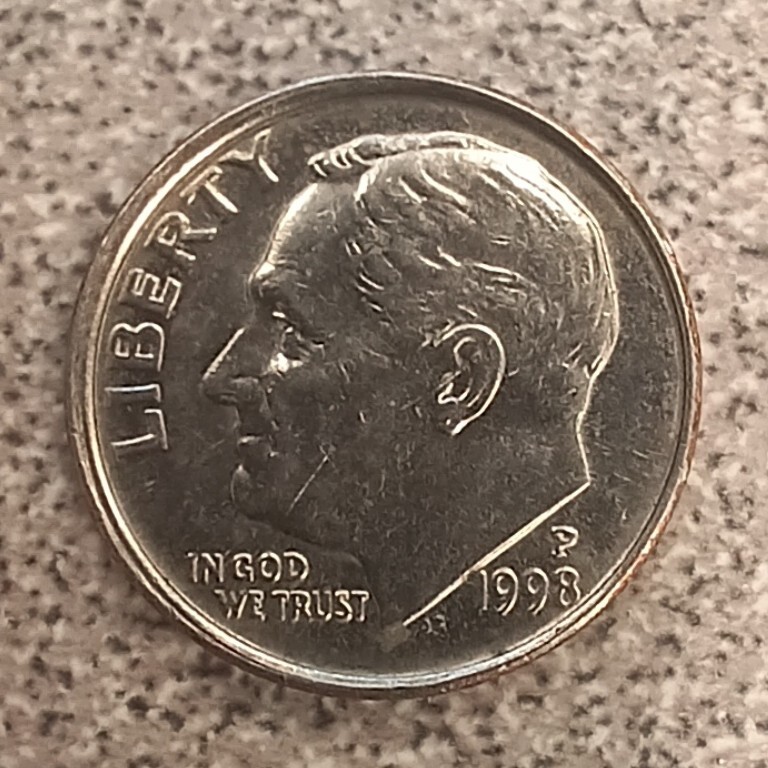1998 Roosevelt dime off-center strike error showing blank crescent and partial design